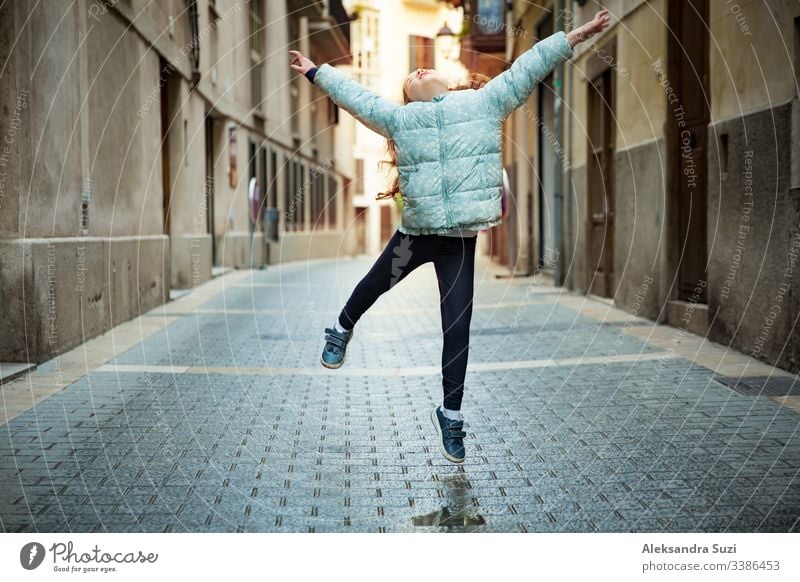 Ein süßes kleines Mädchen tanzt auf der Straße der Stadt. Enge Straßen der Altstadt von Palma de Mallorca. aktiv schön sorgenfrei Kind Kindheit Kinder Großstadt