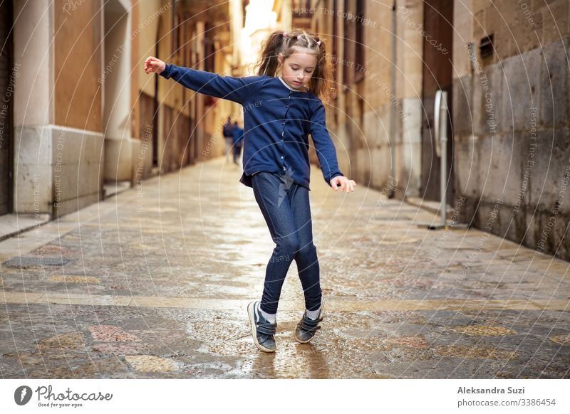 Ein süßes kleines Mädchen tanzt auf der Straße der Stadt. Enge Straßen der Altstadt von Palma de Mallorca. aktiv schön sorgenfrei Kind Kindheit Kinder Großstadt