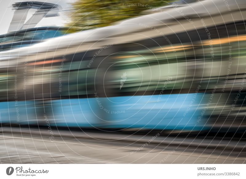 fahrende Straßenbahn mit Bewegungsdynamik Bewegungsunschärfe fahrende s-bahn straßenbahn Tag vorbeifahren bewegen blau grau grün schnell rasend schnell