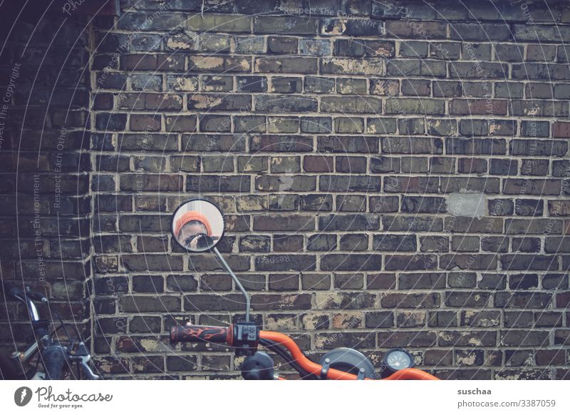 fotografin spiegelt sich im motorradspiegel vor mauer Mauer Motorrad Motorradlenker Motorradspiegel Spiegel Frau Fotografin Außenaufnahme Straße Kleinmotorrad