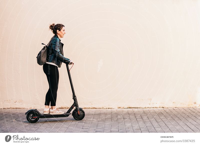 Frau mittleren Alters auf einem Elektroroller aktiv Erwachsener allein attraktiv Hintergrund Holzplatte Business heiter Großstadt fahren e-Scooter Öko