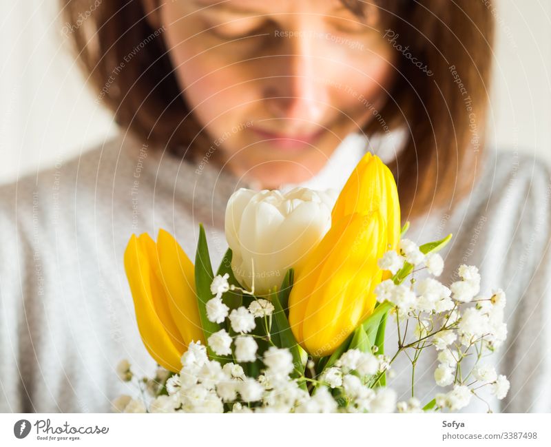 Frau hält Blumenstrauß aus gelben und weißen Tulpen. Frauen, Muttertagskonzept. Haufen Tag geben Frühling Ostern Hände geblümt Dame März Geschenk Einladung Gruß