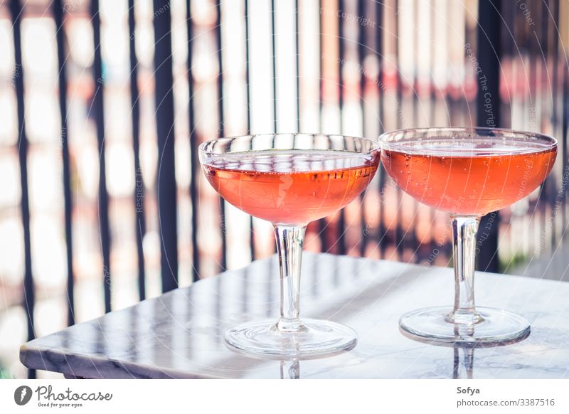 Zwei Kristallstielgläser mit Rosenwein auf Marmortisch im Freien. Aperitifzeit Wein Roséwein weiß Glas Murmel Party rosa trinken Abendessen Tisch Reichtum Licht