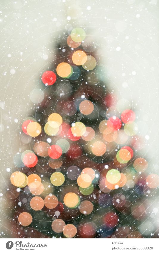 Weihnachtsbaum in Bokeh im Hintergrund mit Schneefall Baum dekorieren festlich pulsierend Illumination lebhaft Zauberei u. Magie Schönheit feiern Formen