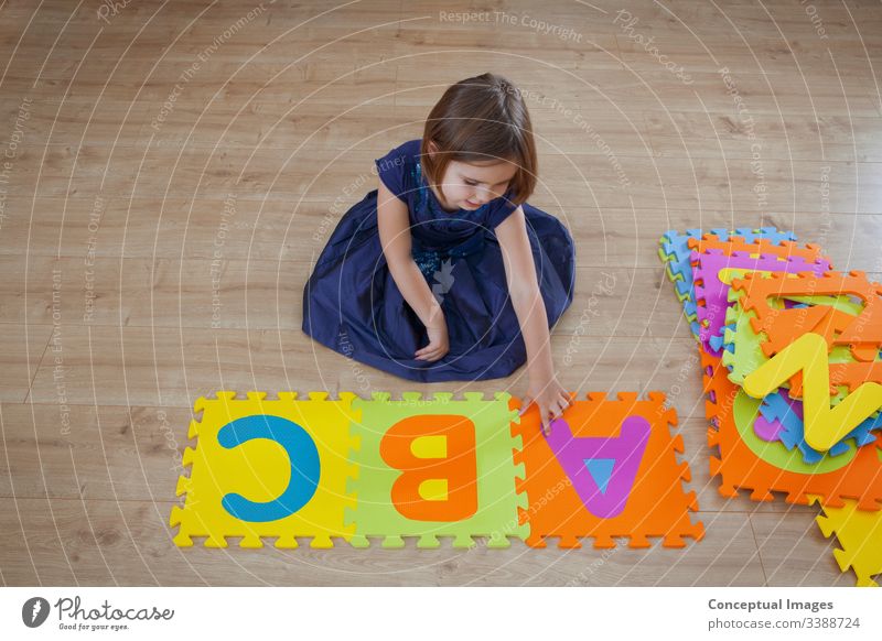 Ein junges Mädchen lernt das Alphabet abc Aktivität hell Kaukasier Kind Kindheit Farbe farbenfroh Konzept Textfreiraum kreativ Tochter Entwicklung Bildung Frau