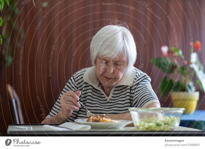 Einsame ältere Frau, die ihr Mittagessen im Altersheim verzehrt. Senior Rentnerin Brieftasche Armut Ruhestand alt in den Ruhestand getreten Essen Großmutter