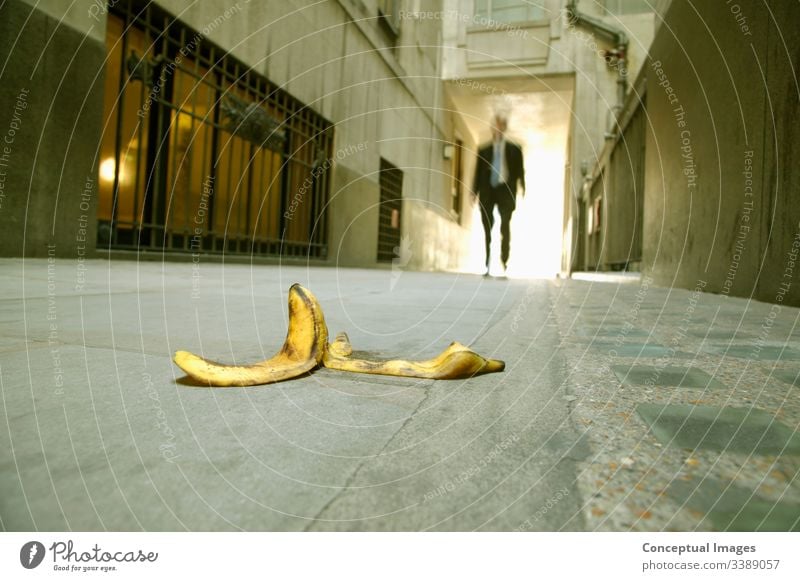 Niedriger Blickwinkel eines Geschäftsmannes, der auf eine Bananenschale zugeht Unfall Seien Sie vorsichtig. Business nachlässig Unachtsamkeit Vorsicht Konzept