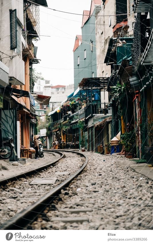 Die Sehenswürdigkeit Train Street in Hanoi; Zuggleise die durch eine enge Gasse, mit Wohnhäusern und Cafés führen Gleise Vietnam gefährlich Touristen wohnen