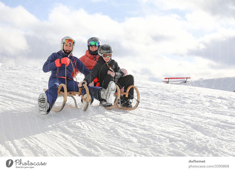 Drei Mädchen haben Rodelspaß Sport Wintersport Berge u. Gebirge Pulverschnee abwärts Skipiste Winterurlaub alpen draußen Schneelandschaft Schneebedeckte Gipfel