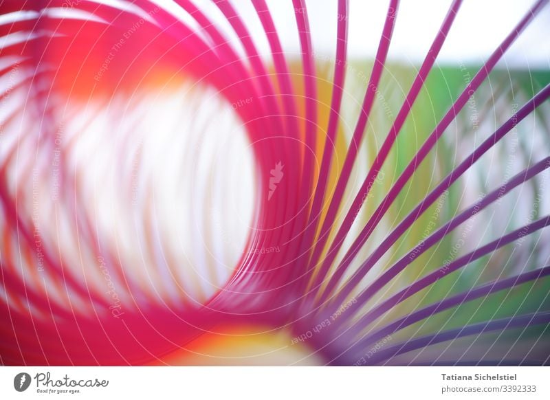 Einzelne Spiralen einer gebogenen Regenbogenspirale / Treppenhüpfer Spielzeug spiralenförmig bunt spiralenlinie mehrfarbig Farbfoto Farbe Nahaufnahme Unschärfe