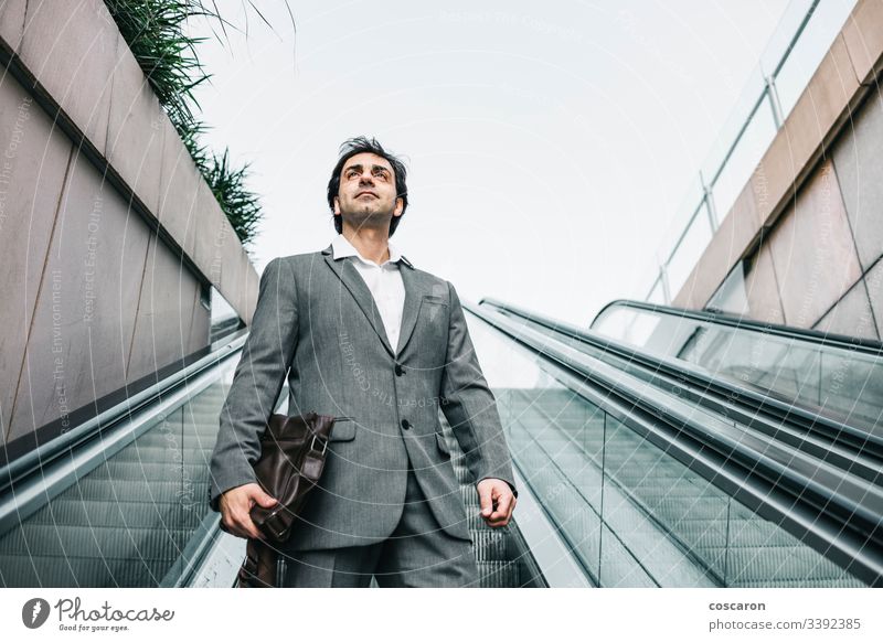 Geschäftsmann im Anzug fährt auf einer Rolltreppe Erwachsener Flughafen attraktiv Chef Business Geschäftsleute Geschäftskleidung Großstadt Kaffee korporativ