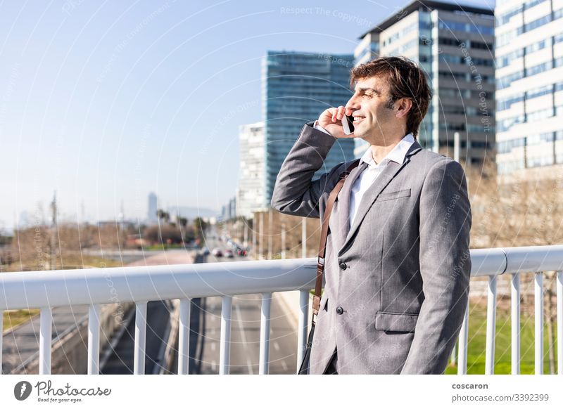 Glücklicher Geschäftsmann mit einem Mobiltelefon in der Stadt Erwachsener Barcelona Brücke Gebäude Business Anruf Funktelefon Großstadt Stadtbild copyspace