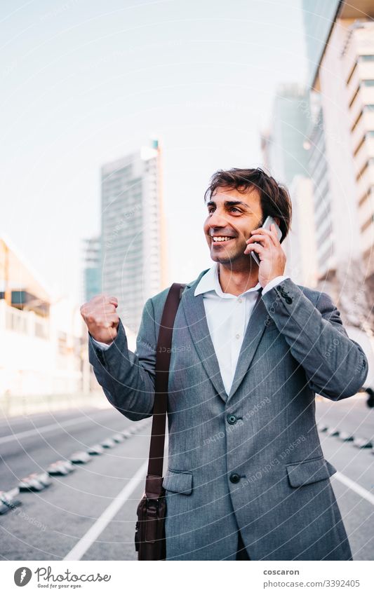 Gutaussehender reifer Geschäftsmann feiert Sieg Errungenschaft Barcelona Vollbart Gebäude Business zu feiern Funktelefon heiter Großstadt Mitteilung Konzept