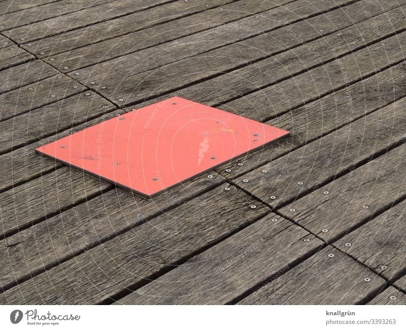 rote rechteckige Abdeckplatte auf geschraubten Holzbodenbrettern Holzbrett braun Strukturen & Formen Menschenleer Außenaufnahme Farbfoto Tag Muster Maserung