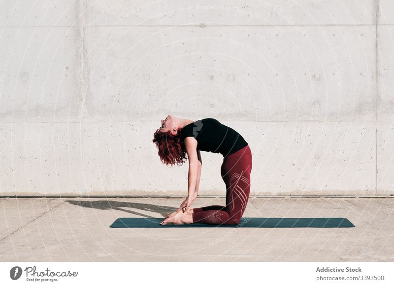 Frau macht Yoga in Kamelpose auf der Straße Dehnung üben Asana Training Übung beweglich Athlet Windstille gymnastisch Beton urban Wellness Wohlbefinden