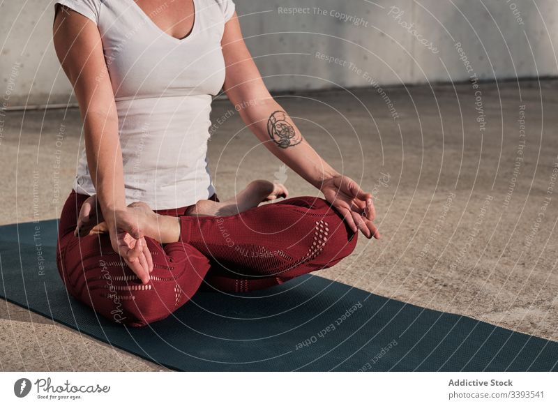 Anonyme Frau meditiert in Lotus-Pose auf der Straße meditieren Yoga ruhig üben gyan mudra beweglich idyllisch gymnastisch Athlet padmasana Barfuß Beton Übung