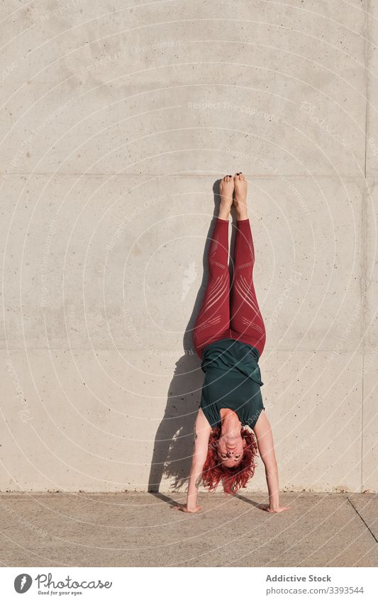 Frau macht Handstand beim Üben von Yoga auf der Straße Übung akrobatisch üben Gleichgewicht Training urban Athlet Barfuß Beton Gesundheit