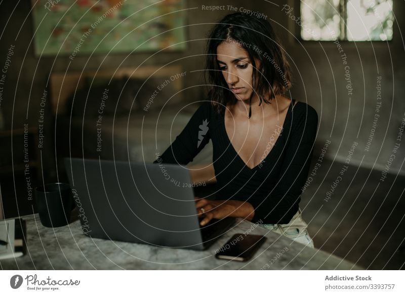 Fokussierte junge Frau benutzt Laptop im Raum benutzend Tippen Mitteilung Anschluss Internet online Surfen Browsen Gerät Apparatur freiberuflich Arbeit