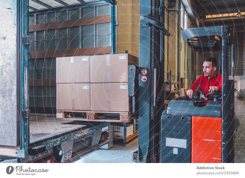 Männlicher Arbeiter einer Logistikfirma in einem Gabelstapler Mann Fahrer Stapler Versand PKW Lager Lagerhalle Maschine Gerät modern Betreiber männlich Dienst