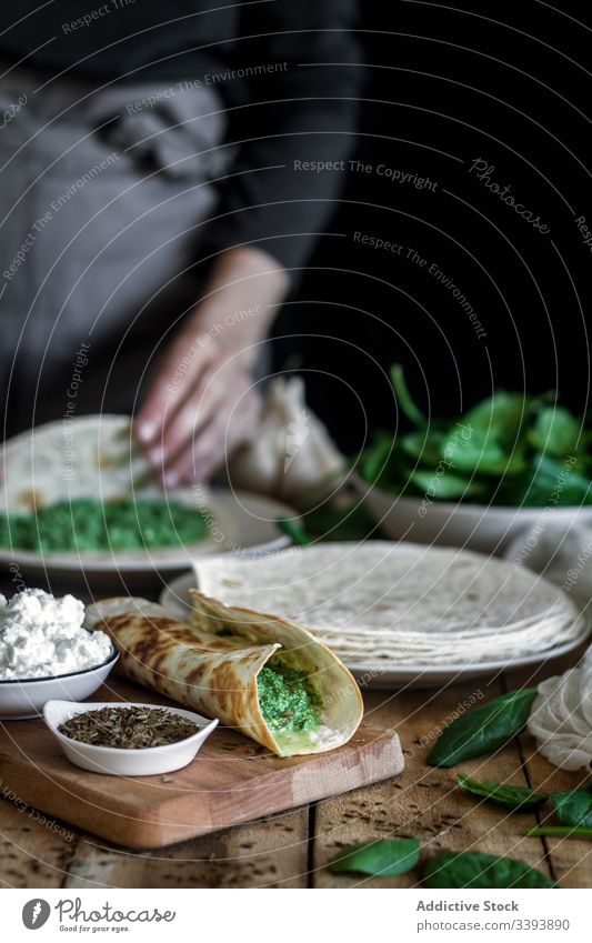 Fajitas aus gegrilltem Spinat, serviert mit Hüttenkäse und Sauce fajitas Tortilla Saucen Grillrost Tisch Bestandteil farbenfroh grün Speise Küche geschmackvoll
