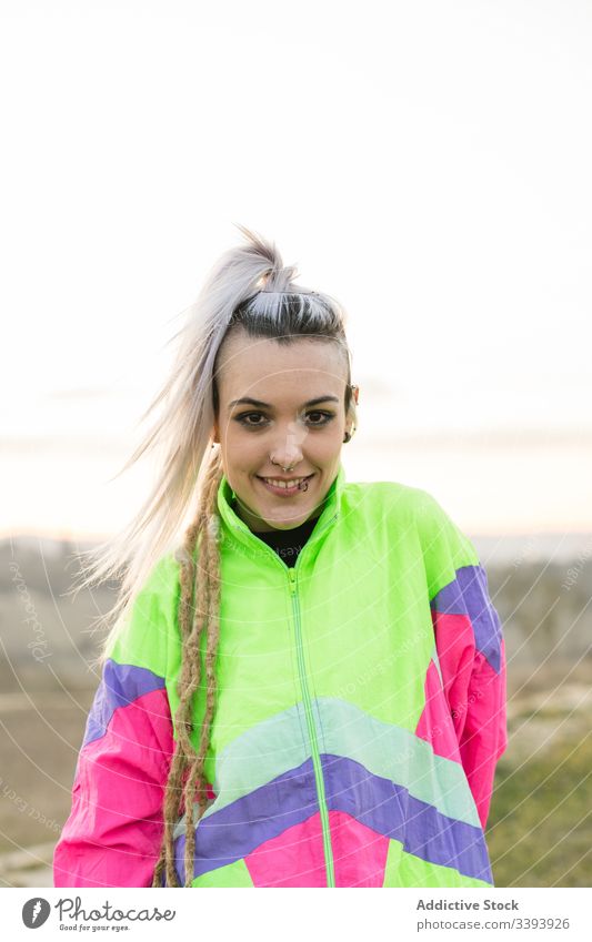 Junge Frau mit moderner Frisur in farbenfroher Sportkleidung Teenager Hipster Sportbekleidung außergewöhnlich besinnlich cool Natur Jacke gefärbtes Haar
