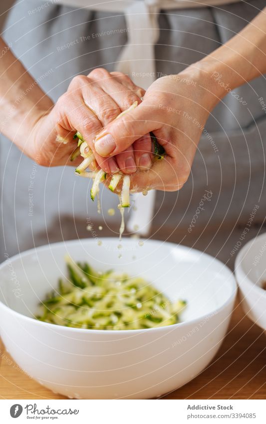 Frau quetscht Zucchini in der Küche Essen zubereiten Lebensmittel Gitter drücken Rezept Gemüse Bestandteil Hände Gesundheit Mahlzeit Hausfrau Abendessen