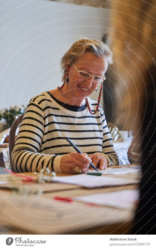 Künstlerin zeichnet mit Bleistift im Kunstatelier Frau Beschriftung Handschrift zeichnen Konzentration kreativ Fokus Lifestyle lernen Job sitzen Skizze