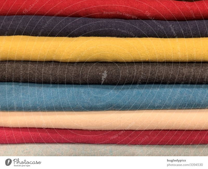 Verschiedene einfarbige Stoffe (gelb, blau, rot, beige, grau) übereinander gelegt Wolle Wollwaren bunt gemischt mehrfarbig Nahaufnahme Streifen quer weich