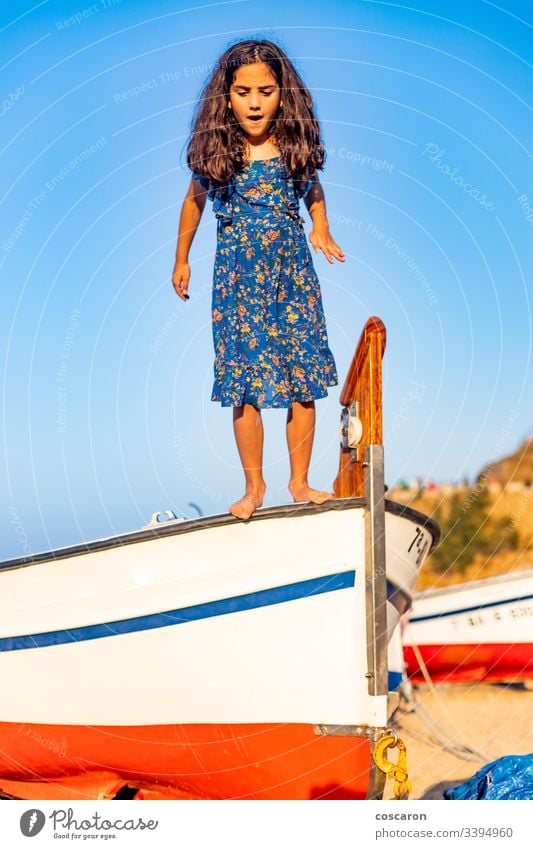 Kleines Kind, das aus einem Boot mit blauem Himmelshintergrund springt aktiv Air Hintergrund Strand schön Junge sorgenfrei heiter Kindheit Küste Küstenlinie