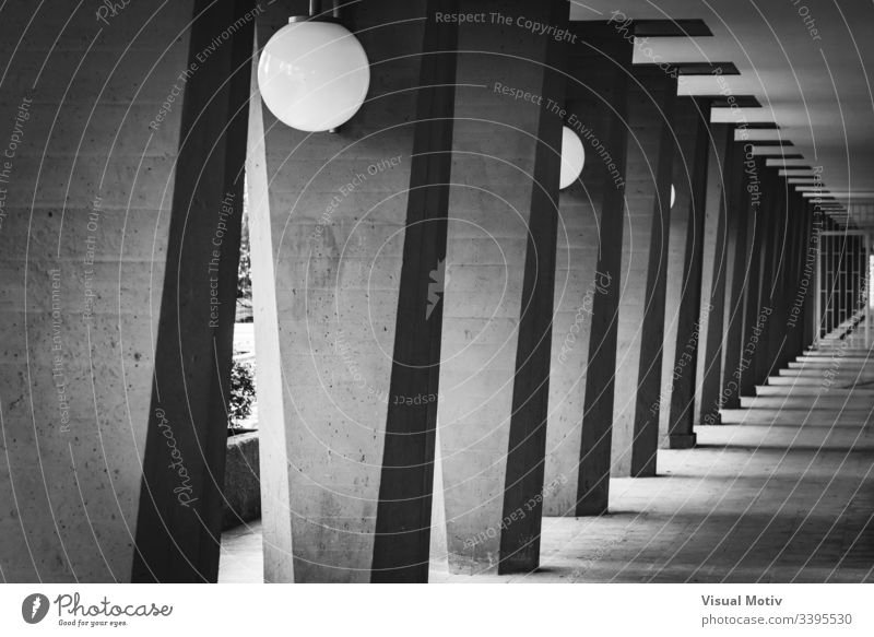 Außenflur mit Säulen in Schwarz-Weiß schwarz auf weiß Graustufen-Fotografie Kontrast Lampen im Freien Außenseite Struktur Perspektive Spalten abstrakt