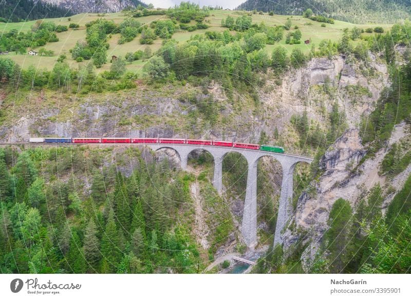 Roter Schnellzug fährt auf der berühmten Landwasser-Brücke in Filisur, dem Herzen der alpinen Berge in der Schweiz Zug landwasser Schweizer Natur Architektur