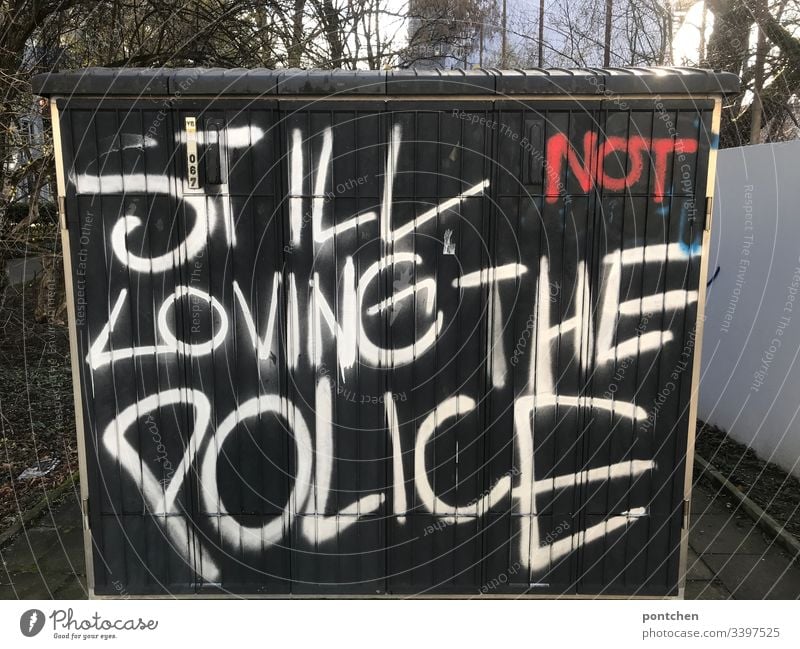Graffiti auf einem Stromkasten. Englische r Text über die  Abneigung  gegenüber der  Polizei. Polizeigewalt abneigung graffiti stromkasten schwarz text satz