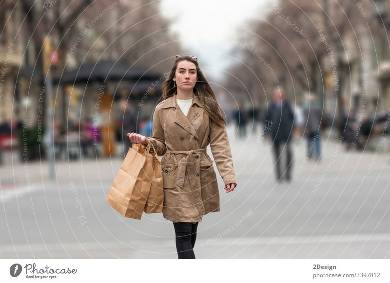 Junge Frau geht auf der Straße mit einer Einkaufstasche in der Hand Teenager gemischte Rasse Barcelona schön fallen asiatisch europa Glück Käufer Mode Spanien