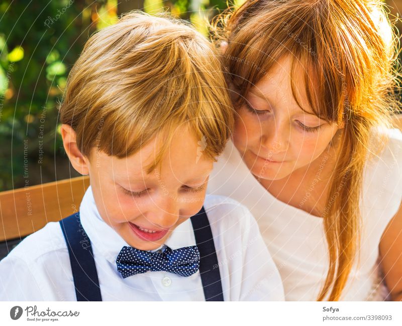 Elegante Kinder entspannen sich bei einer Hochzeit Mädchen Technik & Technologie benutzend Smartphone Junge Glück Mobile Telefon herumhängen Pause Ringträger