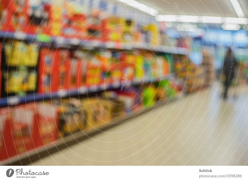 Verschwommene, bunte, volle Regale im Supermarkt und Kunde im Hintergrund Unschärfe Käufer Konsum Verbraucher bunt gemischt unscharf Neon-Beleuchtung