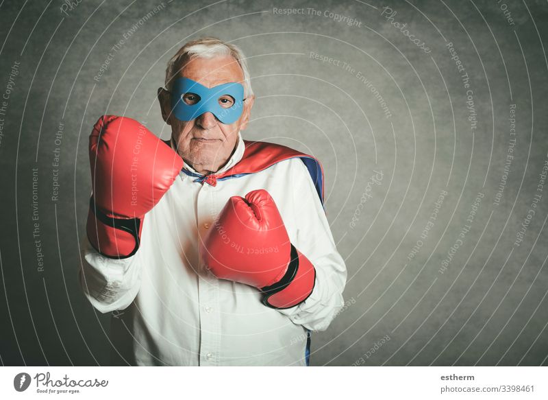 Super-Opa, älterer Mann, gekleidet als Superheld. Großvater Kraft Sieg in den Ruhestand getreten Rente Menschen Senior Kavalier Ausdruck Einstellung Mundschutz