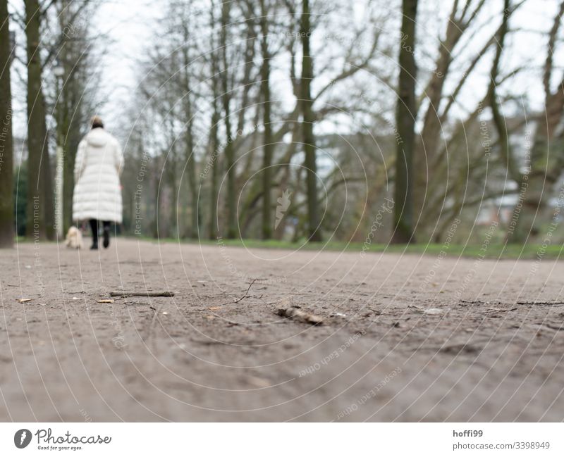 Kippe im Park zigarettenkippe Abfall Müll sorglosikeit Umweltverschmutzung Problematik dreckig Hund Gassi gehen Frau Tristesse