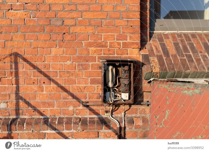 Telefon - alte Sprechstelle an rote Backsteinmauer Telekommunikation Anschluss Telefonhörer Kabel sprechen retro Wählscheibe Büro Kontakt altmodisch