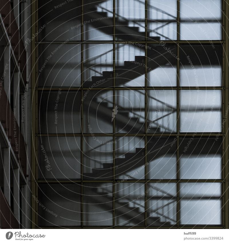Aussenansicht eines Treppenhauses mit matter Fassade aus Glas Schwache Tiefenschärfe Kontrast Licht Schatten Hochhaus Milchglas transparenz diffus dunkel düster
