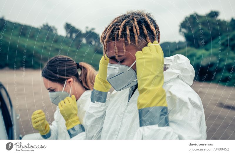 Jugendliche, die Schutzmasken aufsetzen Anlegen von Schutzmasken covid-19 Seuche Pandemie Virus Coronavirus bakteriologischer Schutzanzug Krankheit Gesundheit
