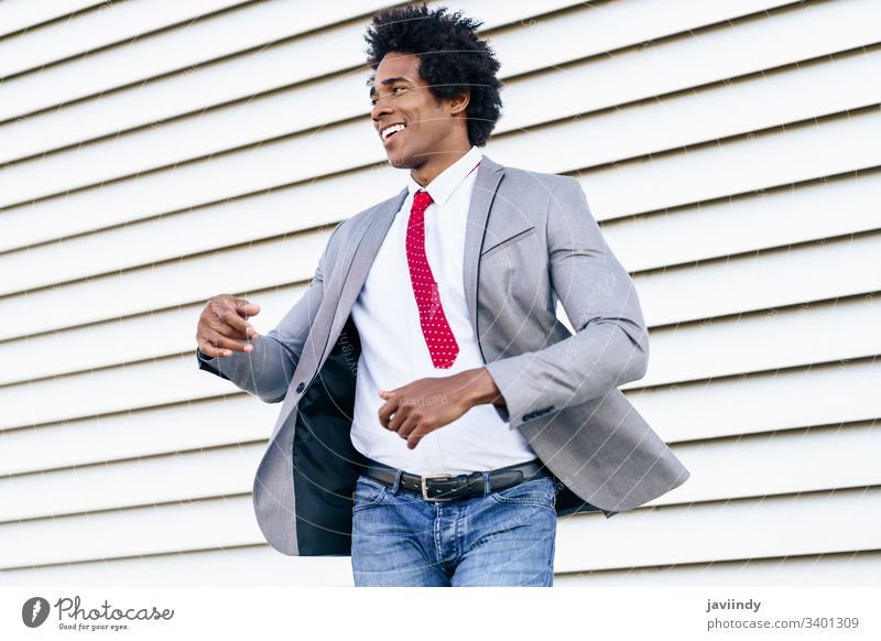 Fröhlicher schwarzer Geschäftsmann im Anzug, der im Freien tanzt. Glück lockig Afro-Look Freude du Behaarung Afrikanisch männlich Erwachsener Porträt Amerikaner