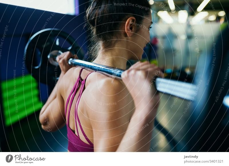 Athletische Frau im Fitnessstudio beim Heben von Gewichten im Fitnessstudio Gewichtheben Training passen Übung Sport Sportbekleidung Lifestyle jung sportlich