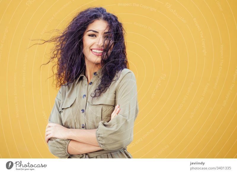 Junge arabische Frau mit lockigem Haar im Freien Behaarung Frisur Lächeln schön Mädchen Schönheit jung eine Mode copyspace nahöstlich gelb grün Model
