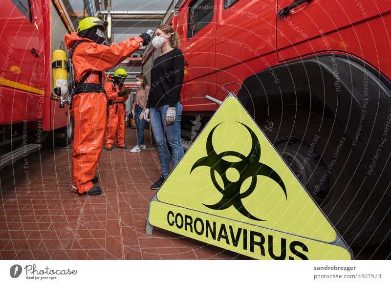 Feuerwehrleute in Seuchenschutzanzügen untersuchen Personen mit Verdacht auf Corona Virus Coronavirus COVID-19 Krankheit Pandemie Epidemie Mundschutz Maske