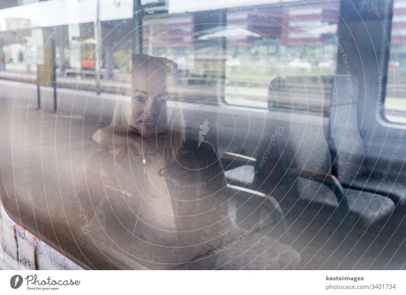 Junge Frau, die mit dem Zug reist und dabei aus dem Fenster schaut, während sie im Zug sitzt. Mädchen reisen jung Passagier Mitfahrgelegenheit Eisenbahn