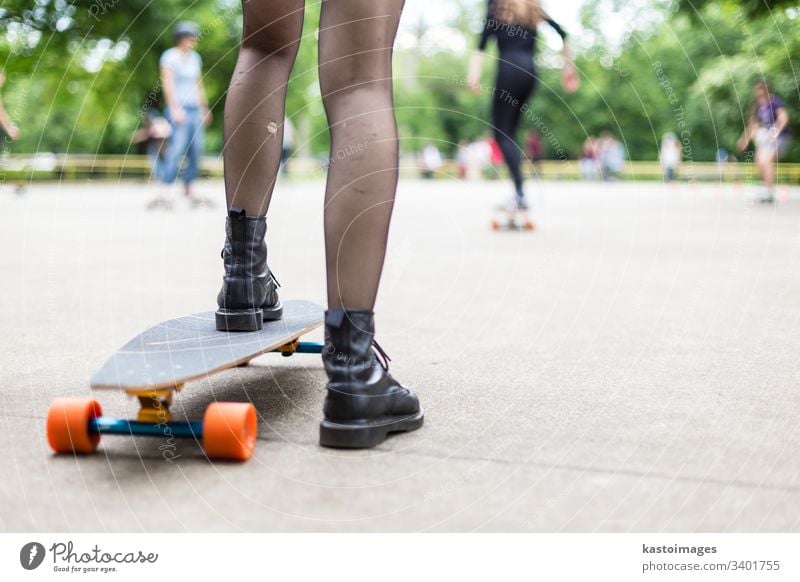 Mädchen in schwarzen Stiefeln und Strümpfen beim Longboardfahren im Skateboard-Park. Aktives städtisches Leben. Städtische Subkultur. urban Holzplatte Sport
