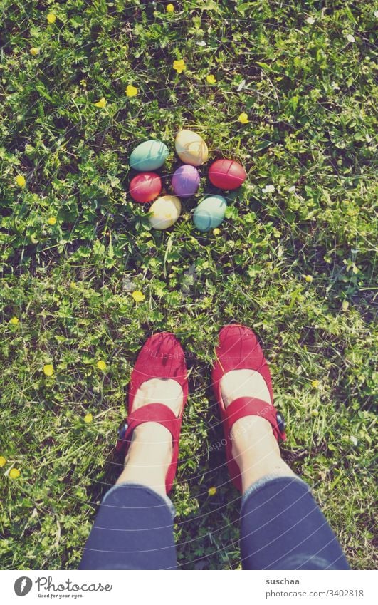 frau steht auf dem gras vor bunten ostereiern Frau stehen Beine Füße Damenschuhe rot Ostern Ostereier farbig gefärbt Schuhe bunte Eier gekochte Eier