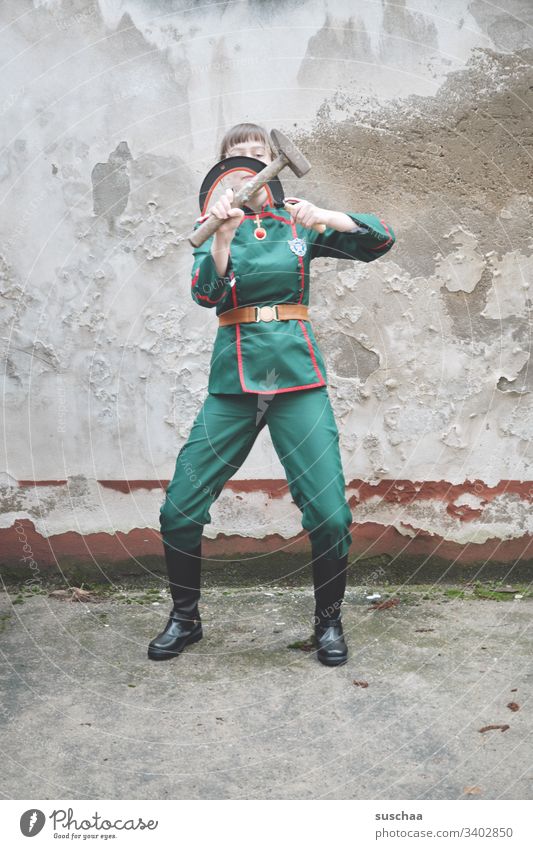 jugendliche in uniform spielt mit sichel und hammer Jugendliche Teenager junge Frau Uniform Soldat Komikerin Spaß seltsam lustig Mensch Karnevalskostüm verrückt