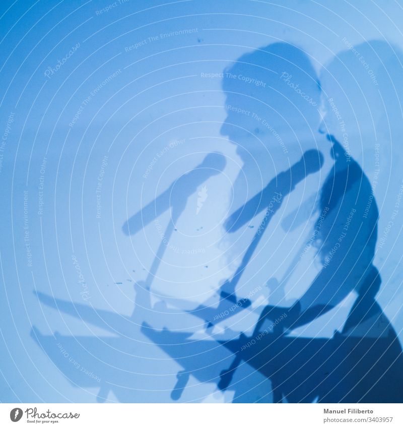 Doppelter Schatten einer Person, die durch ein Mikrofon auf einer blauen Wand spricht Rede Konzert Silhouette männlich Musik Party live Sitzung Leistung Pop