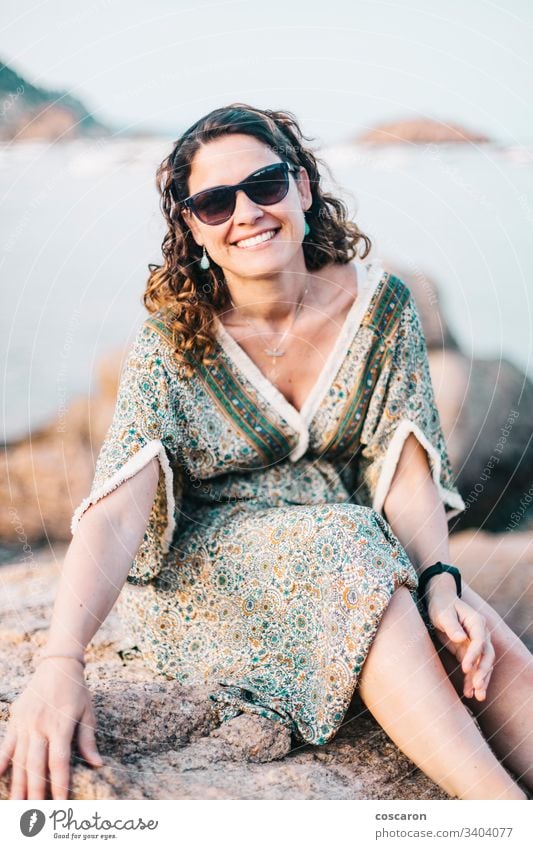 Porträt einer Frau mit Brille an einer Felsenküste Erwachsener attraktiv Hintergrund Strand schön Schönheit blau Brise Schlucht Kaukasier Küste Kleid Emotion